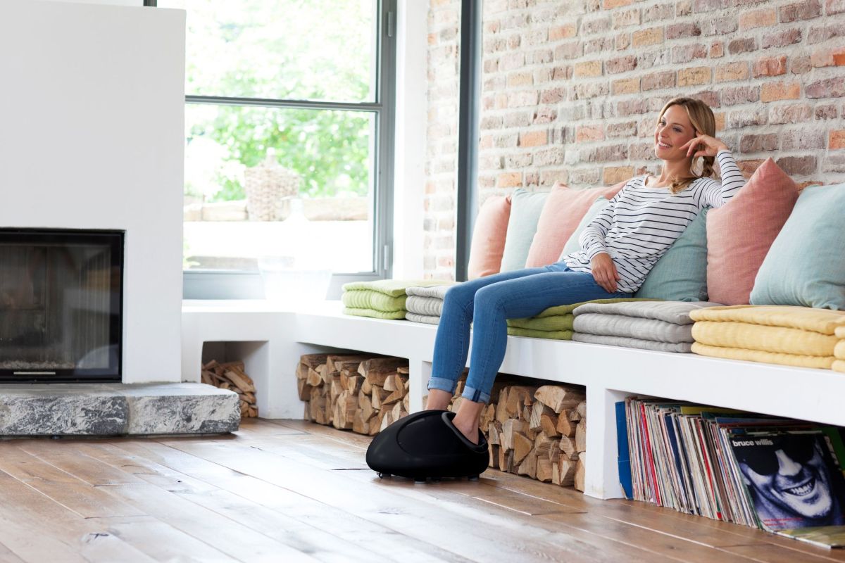 Woman relaxes at home with the medisana FM 888 foot massager - soothing shiatsu massage for tired and tense feet